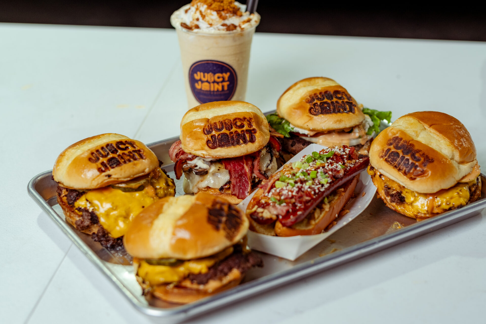 Spread of burgers, shakes, and hot dogs on table